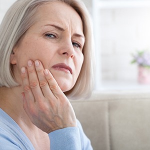 Woman rubbing her jaw due to discomfort