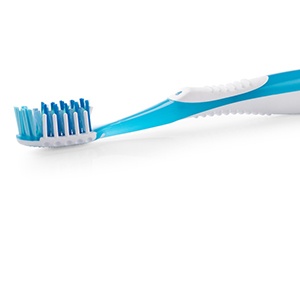 Close-up of a toothbrush with a blue handle 