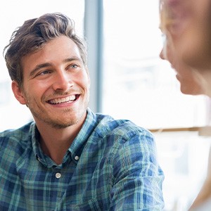 Man in blue shirt smiling at friend