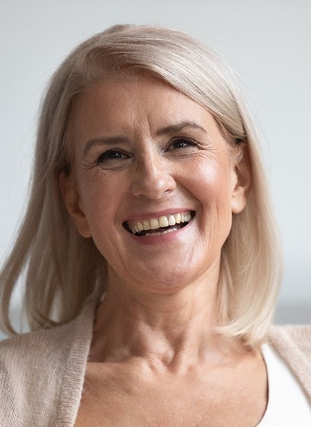 Woman smiling after visiting a cosmetic dentist in Manchester