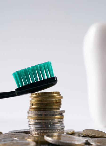 Pile of coins next to a tooth