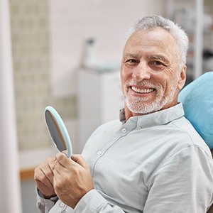 man smiling after getting dentures in Manchester