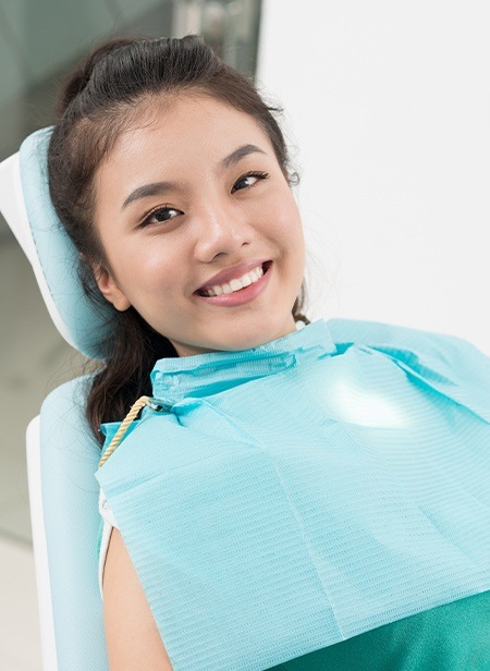 Smiling woman at dental office for tooth extraction