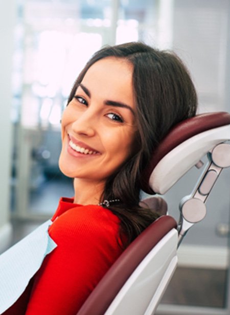 Female dental patient in red shirt smiling