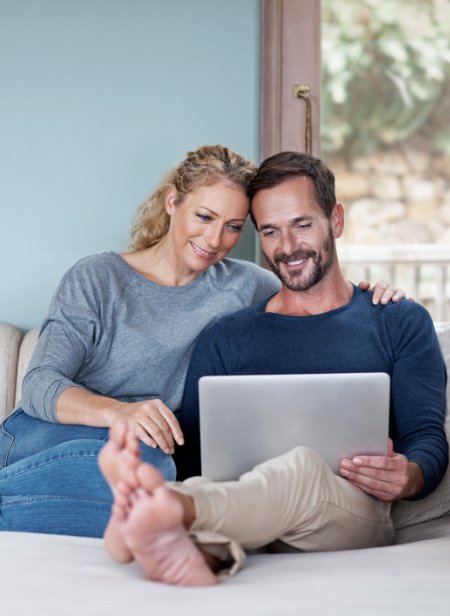 couple looking at dental forms on their laptop computer