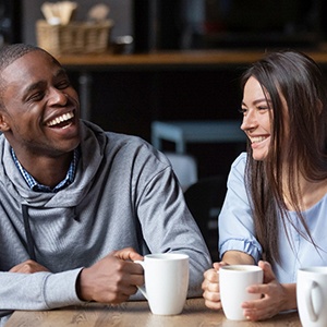 friends sitting around a table conversing and drinking coffee