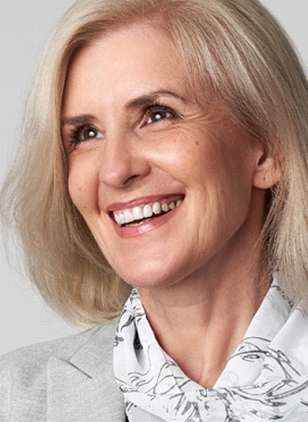 Older woman smiling wearing a white scarf