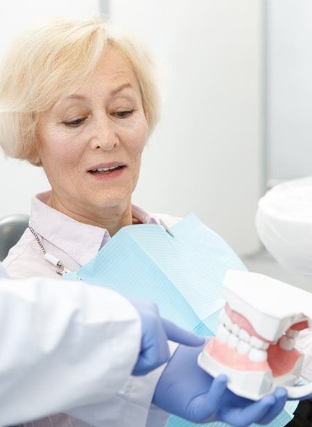 Woman learning about dental implants in Manchester with dentist