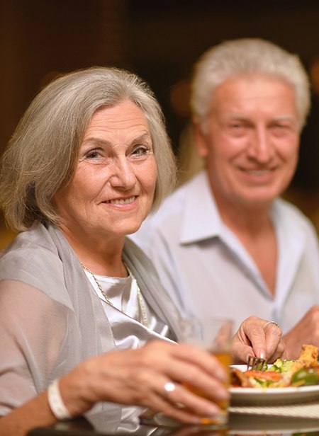 Older couple smiling and enjoying a meal together