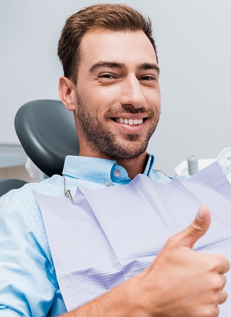 Bearded male dental patient giving a thumbs up