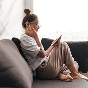 Woman with glasses resting at home on couch