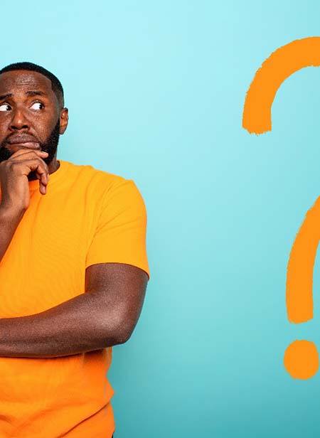 Man with orange question mark wondering about dental implants in Manchester