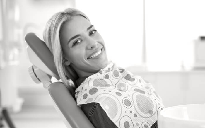 Smiling woman leaning back in dental chair