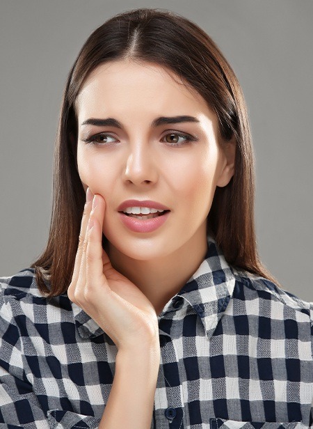 Woman in need of root canal therapy holding jaw