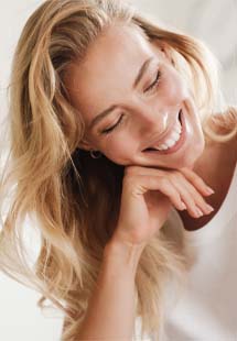 Woman smiling after dental implant tooth replacement