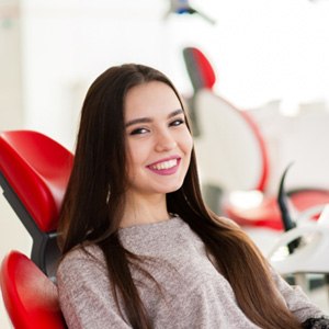 woman smiling while sitting in dental chair