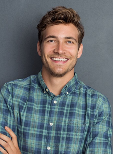 A man smiling and folding his arms.