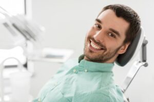 Man smiling after having his Invisalign attachments removed