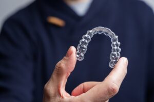Man holding up his Invisalign tray