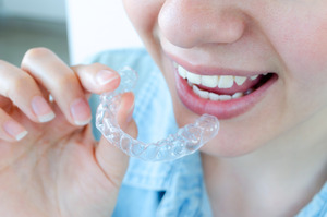 Close-up of person about to put in Invisalign aligner